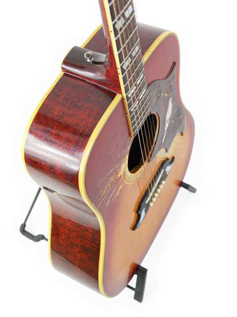 1968 Vintage Gibson Dove guitar with a rich wooden body, elegantly displayed on a wooden stand.