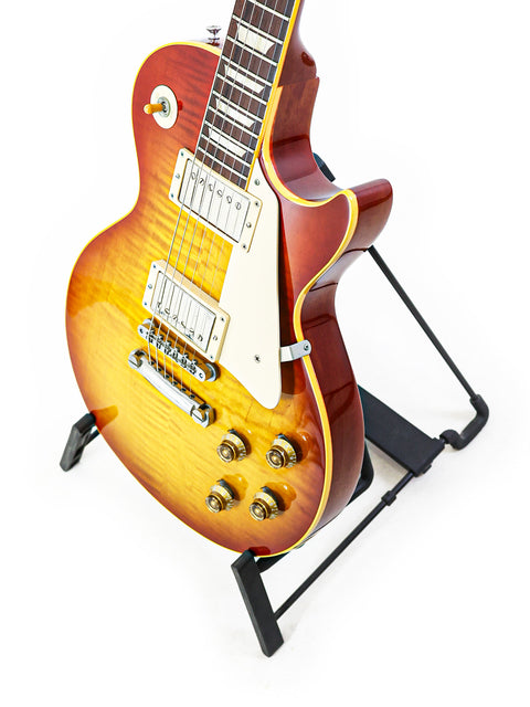 A 2004 Gibson Custom Shop 1959 Reissue Les Paul R9 guitar displayed on a stand with a white backdrop.