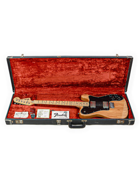 A 1973 Fender Telecaster Deluxe guitar in a bold red case, emphasizing its vintage charm and iconic design.