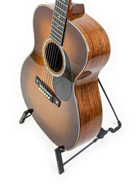 A 2019 Martin Custom Shop 000-42 guitar, featuring Guatemalan Rosewood, resting on a stand with a simple white background.