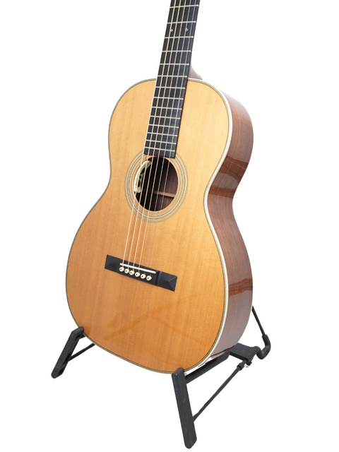 A Martin 0-28VS guitar from the USA, 2011, showcased on a stand against a bright white background.
