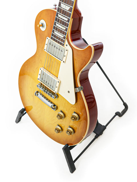 A beautiful Gibson Custom Shop LPR-8 1958 Les Paul Reissue guitar on a stand, showcased with a pristine white background.