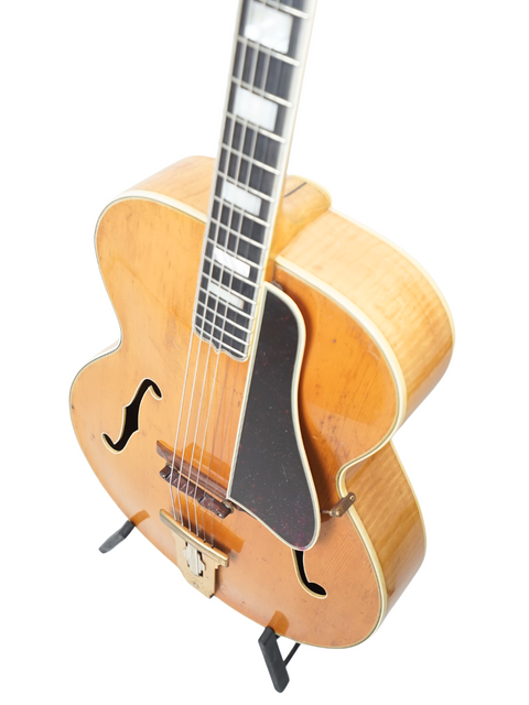 A classic 1939 Gibson L-5 guitar featuring a wooden body and a stylish black pick guard, perfect for any music lover.