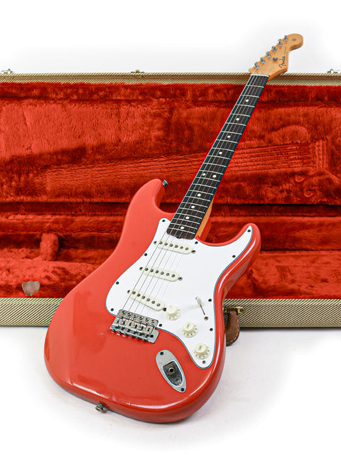 A classic red Fender AVRI ‘62 Stratocaster electric guitar from 1982, resting in its protective case, ready to rock.