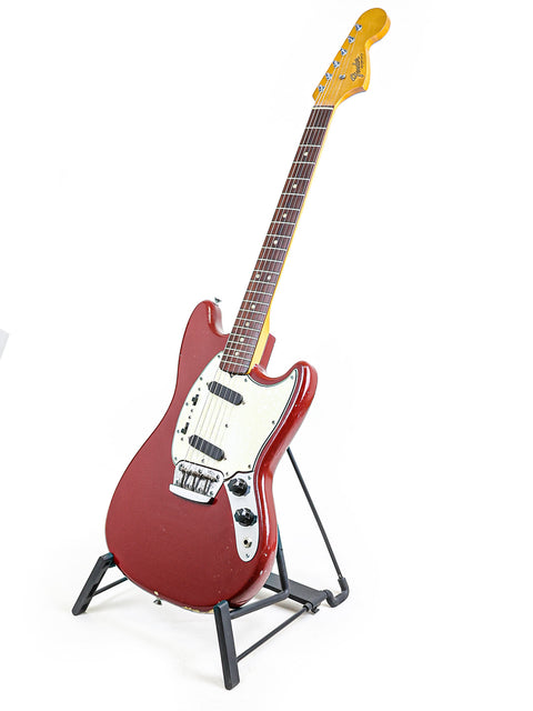 A classic red Fender Musicmaster II guitar from 1966, showcased on a stand with a bright white background.