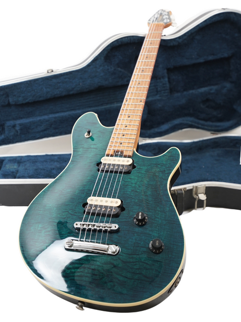 A green Peavey EVH Wolfgang Standard Hardtail electric guitar nestled in a protective case, showcasing its vibrant color.