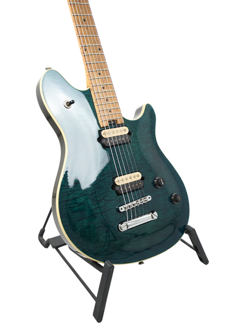 A green Peavey EVH Wolfgang Standard Hardtail electric guitar resting on a stand, highlighting its unique color and craftsmanship.