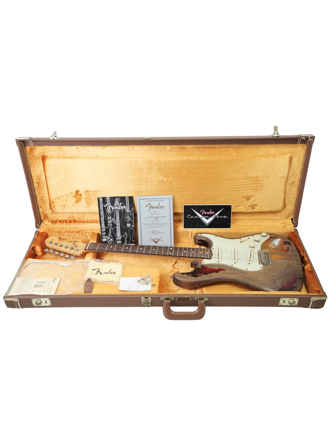 A guitar in a wooden case, labeled as a Fender Custom Shop Rory Gallagher Stratocaster, highlighting its relic finish.