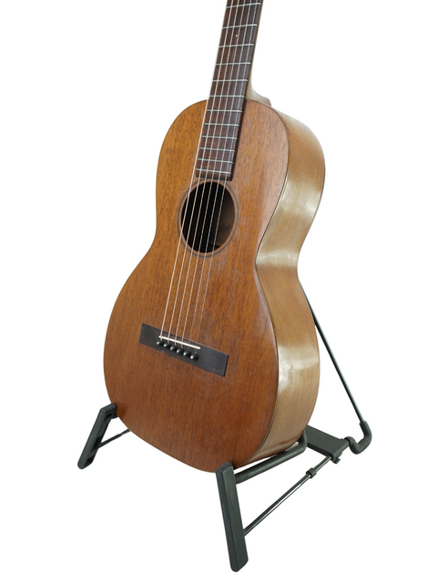 A small wooden-bodied Martin 2-17 Flat Top guitar from 1928 displayed on a stand, highlighting its vintage charm.