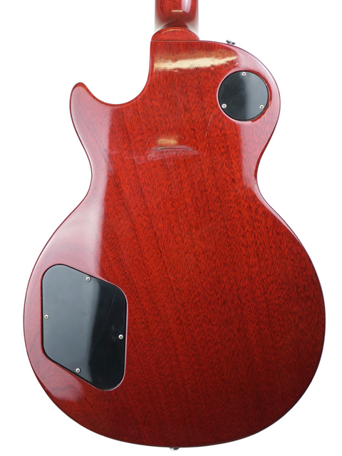 A striking red Gibson Les Paul Standard guitar with a sleek black pickguard, showcasing its 2005 USA craftsmanship.