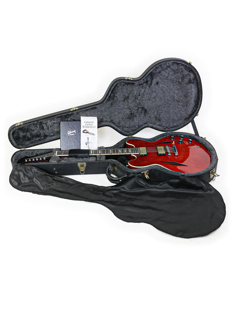 A striking red guitar case containing a Gibson Custom Shop Trini Lopez guitar, highlighting its unique design and quality.