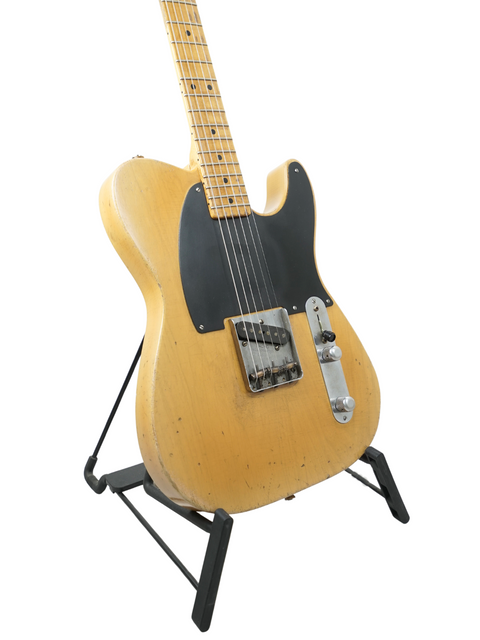 A stylish Fender guitar on a stand, set against a white background, highlighting the Nacho Guitars 50s Stratocaster from Spain, 2024.