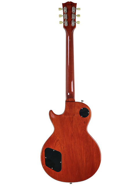 A vibrant red Gibson Les Paul '59 Reissue electric guitar, highlighting its wooden body and iconic design from 2009.