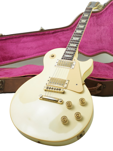 A vintage 1989 Gibson Les Paul Standard electric guitar in Arctic White, accompanied by its case for safe storage.