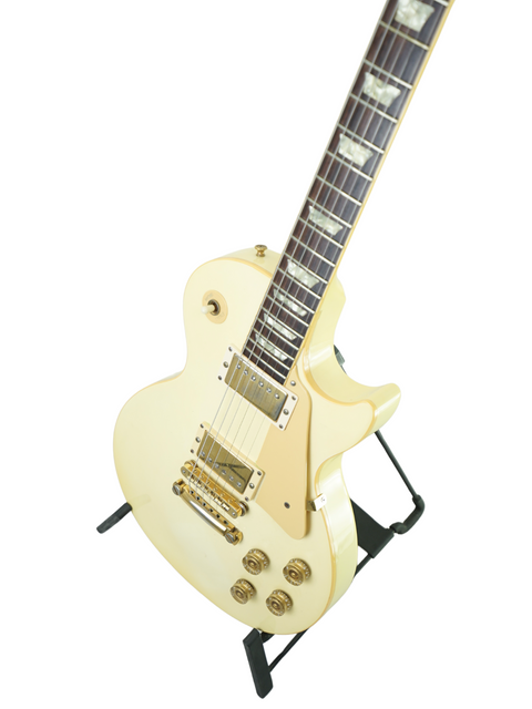 A vintage 1989 Gibson Les Paul Standard in Arctic White, resting on a black stand, highlighting its iconic features.