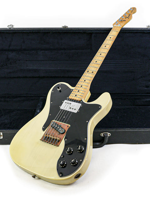 A white electric guitar, the 1978 Fender Telecaster Custom, housed in a stylish black case.