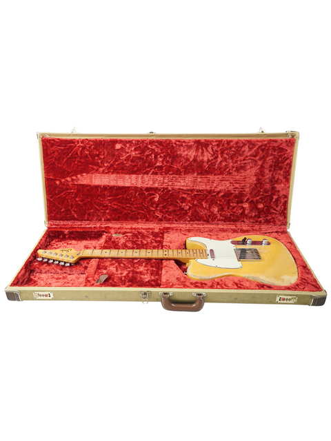 A yellow Suhr Classic T Antique guitar from 2015 peeks out of its case, highlighting its unique heavy aging.