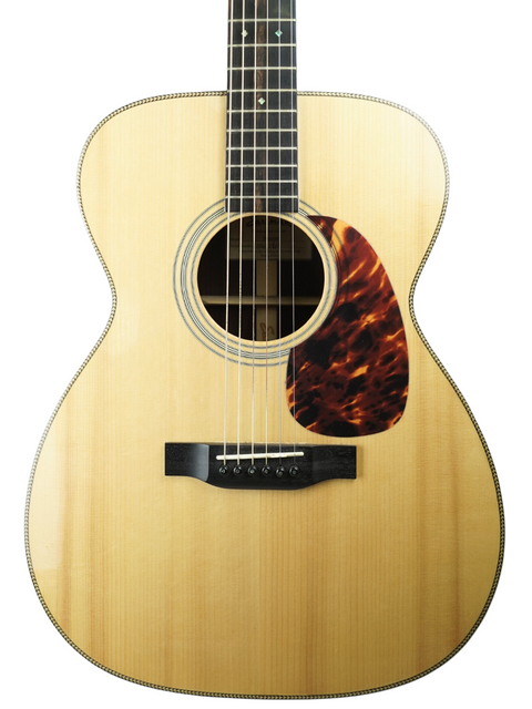 Acoustic guitar with light wood finish and a tortoiseshell pickguard, isolated on white background.