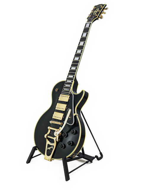 Black and gold Gibson Custom Jimmy Page Les Paul guitar on a stand, limited edition 467/500 from 2008, showcasing elegance.