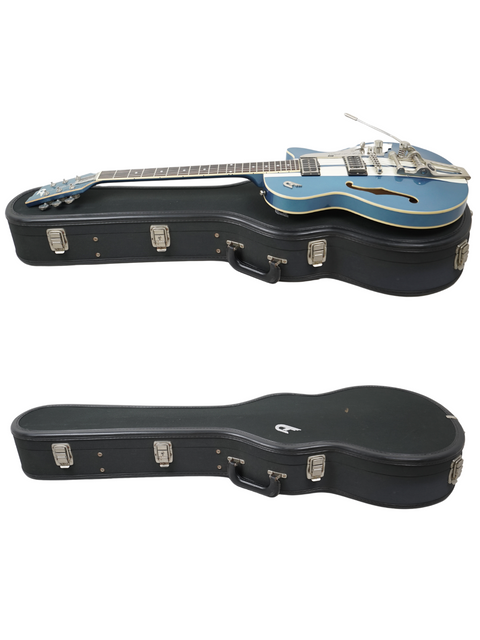Blue electric guitar half-inserted into its black case, both placed against a white background.