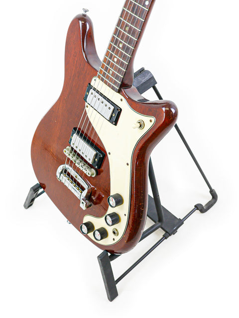 Brown 1966 Epiphone Wilshire guitar displayed on a stand, highlighting its vintage charm and unique features.