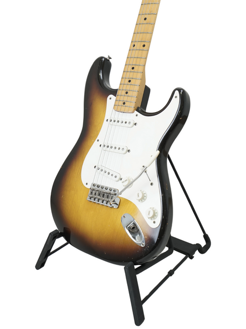 Classic 1957 Fender Stratocaster on a stand, highlighted by a dramatic black background, ex. Hank Marvin.