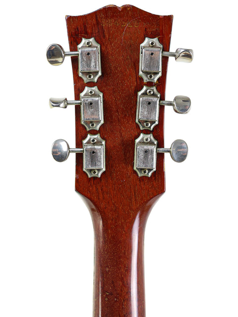 Close-up image of the headstock from a 1965 Gibson ES-330 acoustic guitar, emphasizing its vintage style and intricate details.