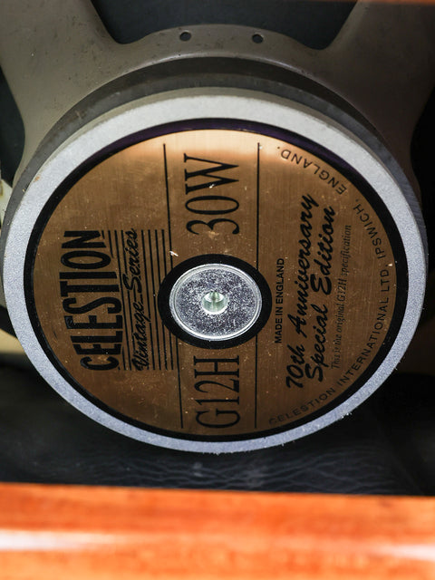 Close-up of a Celestion G12H guitar speaker with label details.