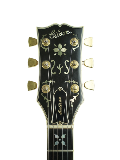 Close-up of a vintage 1978 Gibson Les Paul Artisan electric guitar headstock, showcasing its intricate design and craftsmanship.