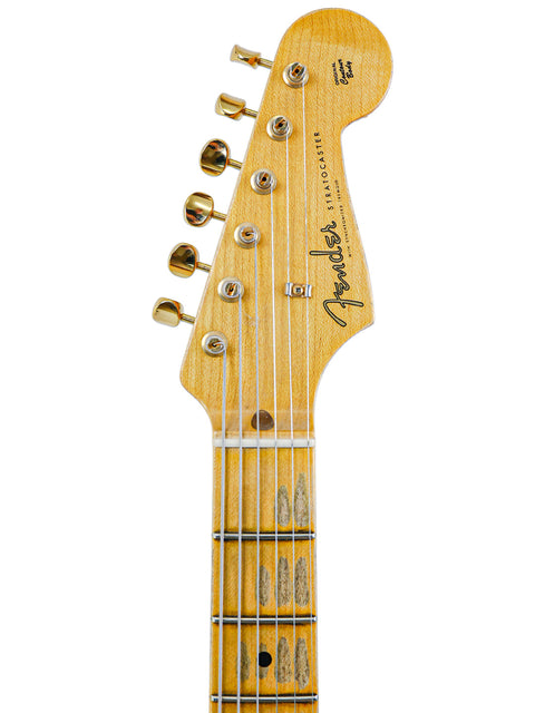Close-up of the headstock and neck of a Fender Stratocaster guitar on a white background.