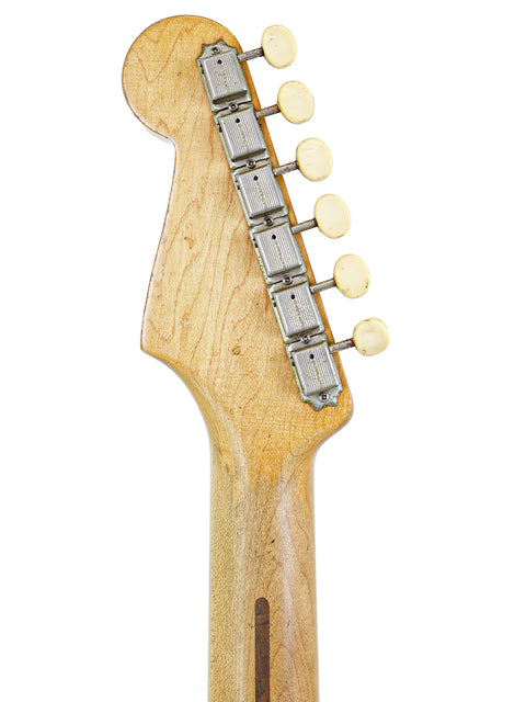 Close-up view of a 1957 Fender Musicmaster guitar head, highlighting the rich wood grain of its body.