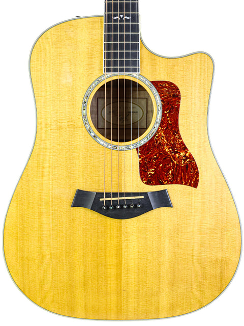Detailed view of a 2003 Taylor 610CE guitar, highlighting its beautiful wood grain and elegant features.
