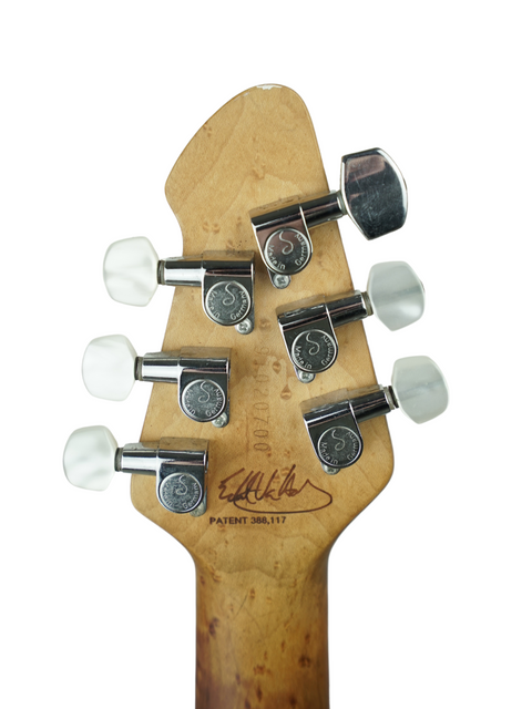 Detailed view of the head of a Peavey EVH Wolfgang Standard Hardtail electric guitar, highlighting the logo and tuning mechanisms.