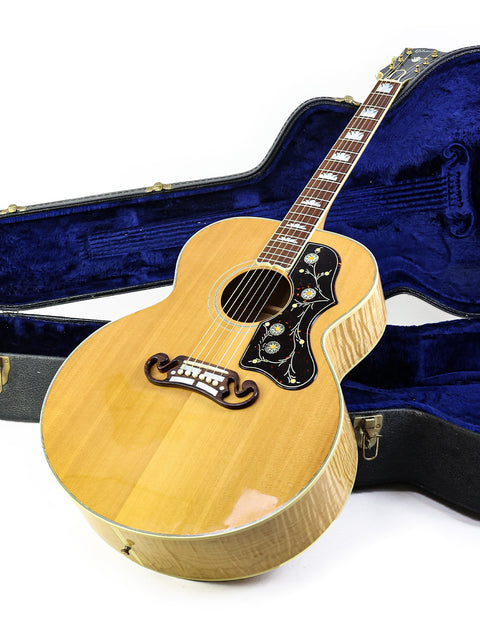 Inside a blue case lies a 1999 Gibson SJ-200 guitar, emphasizing its vintage appeal and quality construction.