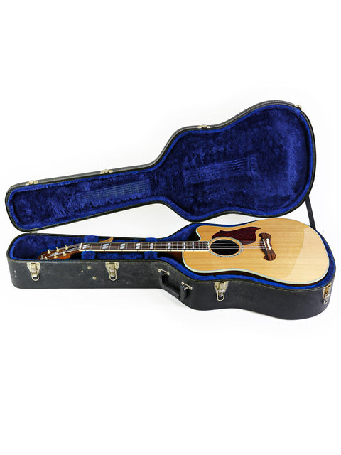 Inside a blue case lies a 2014 Gibson Songwriter Studio Deluxe EC guitar, highlighting its craftsmanship and style.