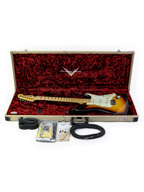 Inside a case, a Fender John Cruz Master Built ‘64 Stratocaster Relic rests with a cable and strap nearby.