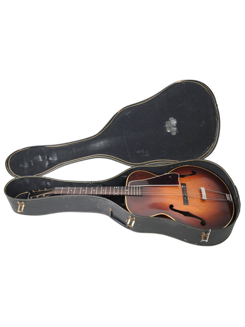 Inside a guitar case lies a vintage 1938 Kalamazoo KG-32, highlighting its historical significance and elegant structure.