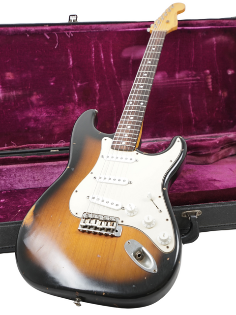 Inside a vibrant purple case lies a Nash S63 Stratocaster Relic guitar, representing quality and vintage charm from 2009.