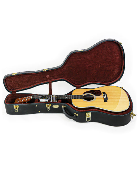 Inside a wooden guitar case, a Martin D-28 CFM IV 55th Birthday Limited Edition guitar from 2009 rests, highlighting its craftsmanship.