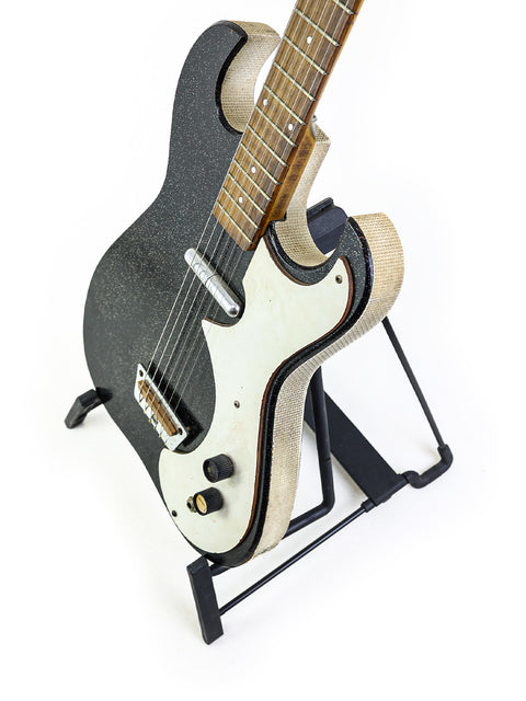 Mid-1960s USA Harmony Silvertone 1448 guitar in black and white, elegantly displayed on a stand with 'Amp-in-Case' design.