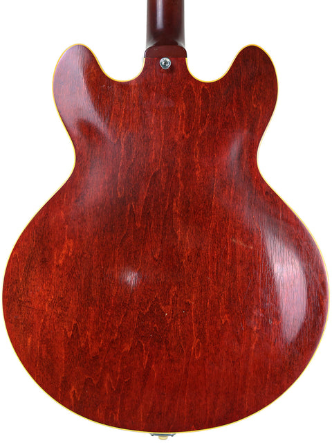 Rear angle of a red-bodied 1965 Gibson ES-330 guitar, emphasizing its vintage design.