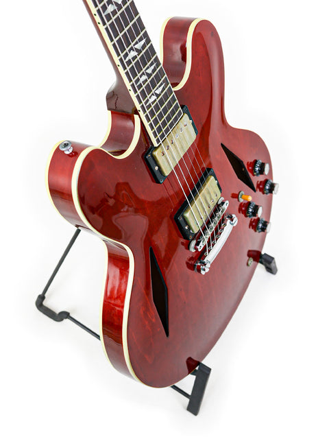 Red Gibson Custom Shop Trini Lopez guitar on a stand, showcasing its vibrant color and unique design from 2009.