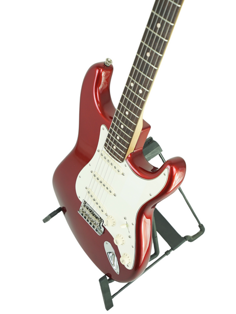 Red electric guitar on a stand against a white background.