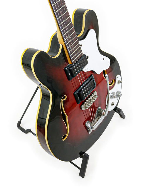 Vintage 1967 Mosrite Celebrity III guitar in black and red, beautifully positioned on a stand.