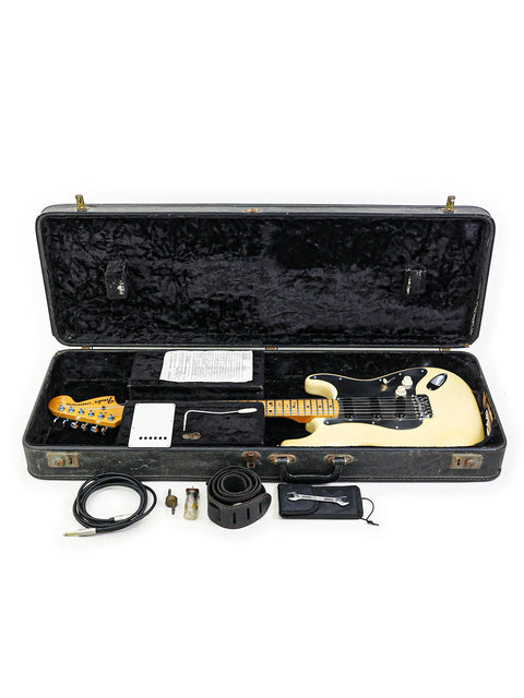 Vintage Fender Stratocaster from 1974, with a cable and accessories, displayed inside a classic guitar case.
