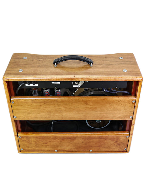 Wooden box with electronic components and a speaker visible inside.