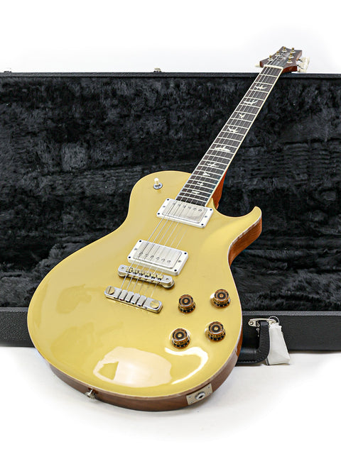 Yellow PRS McCarty Singlecut 594 electric guitar inside a case, featuring a striking design and modern appeal.
