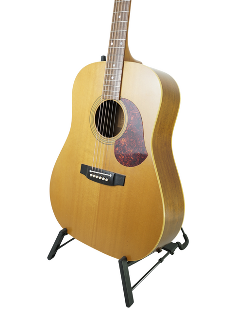 natural-finished Maton EM300 guitar on a stand, prominently featured against a plain white background.
