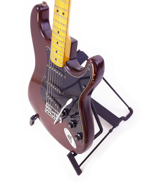 1979 Fender Stratocaster guitar on a black stand, representing vintage craftsmanship and timeless design.
