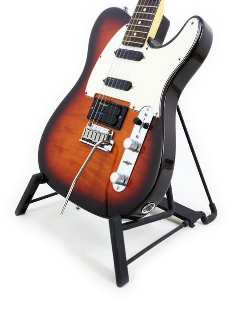 1992 Fender Telecaster Plus Deluxe guitar displayed on a stand, contrasting beautifully with a deep black backdrop.